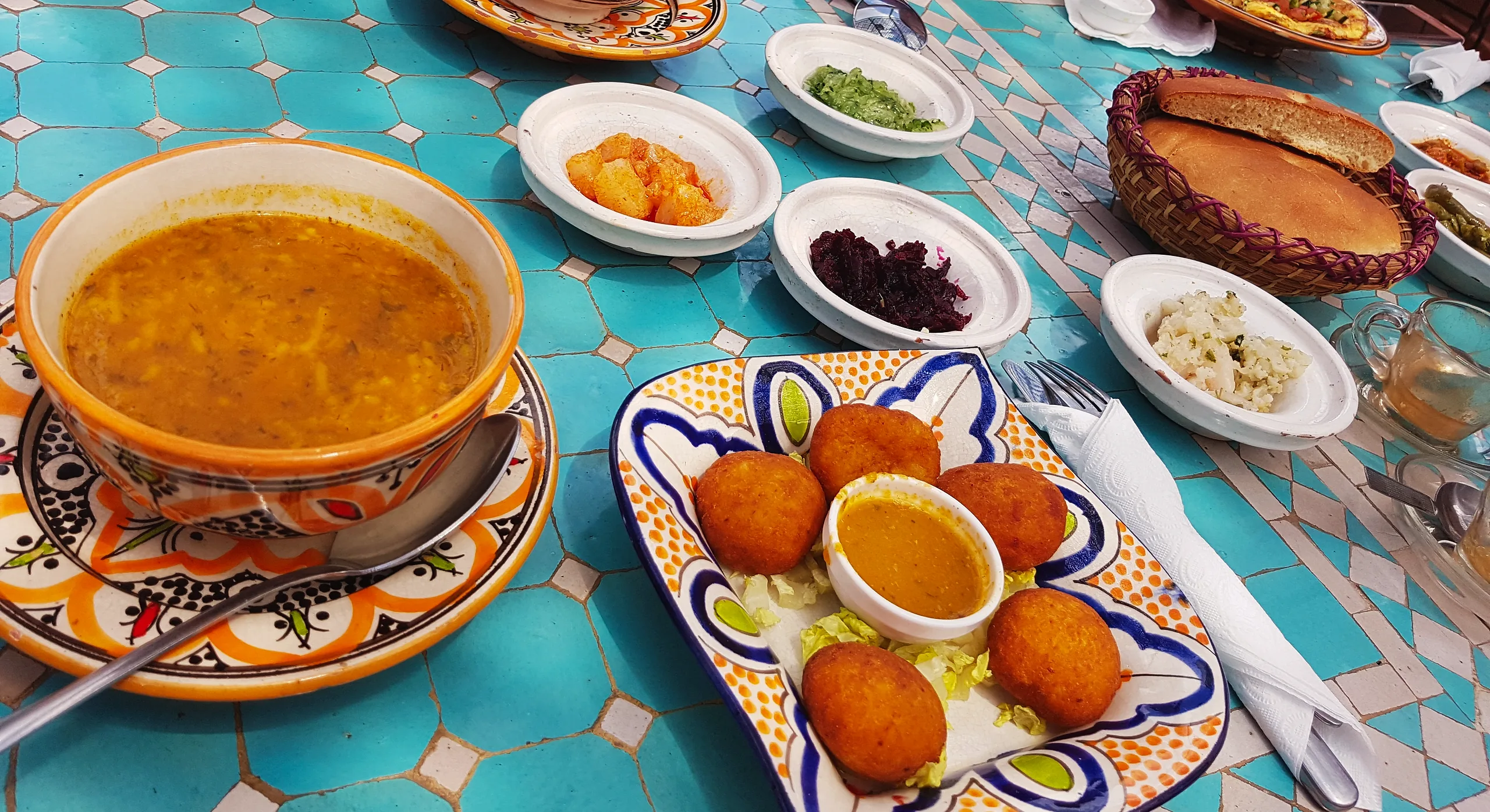 A bowl of harira soup with accompaniments