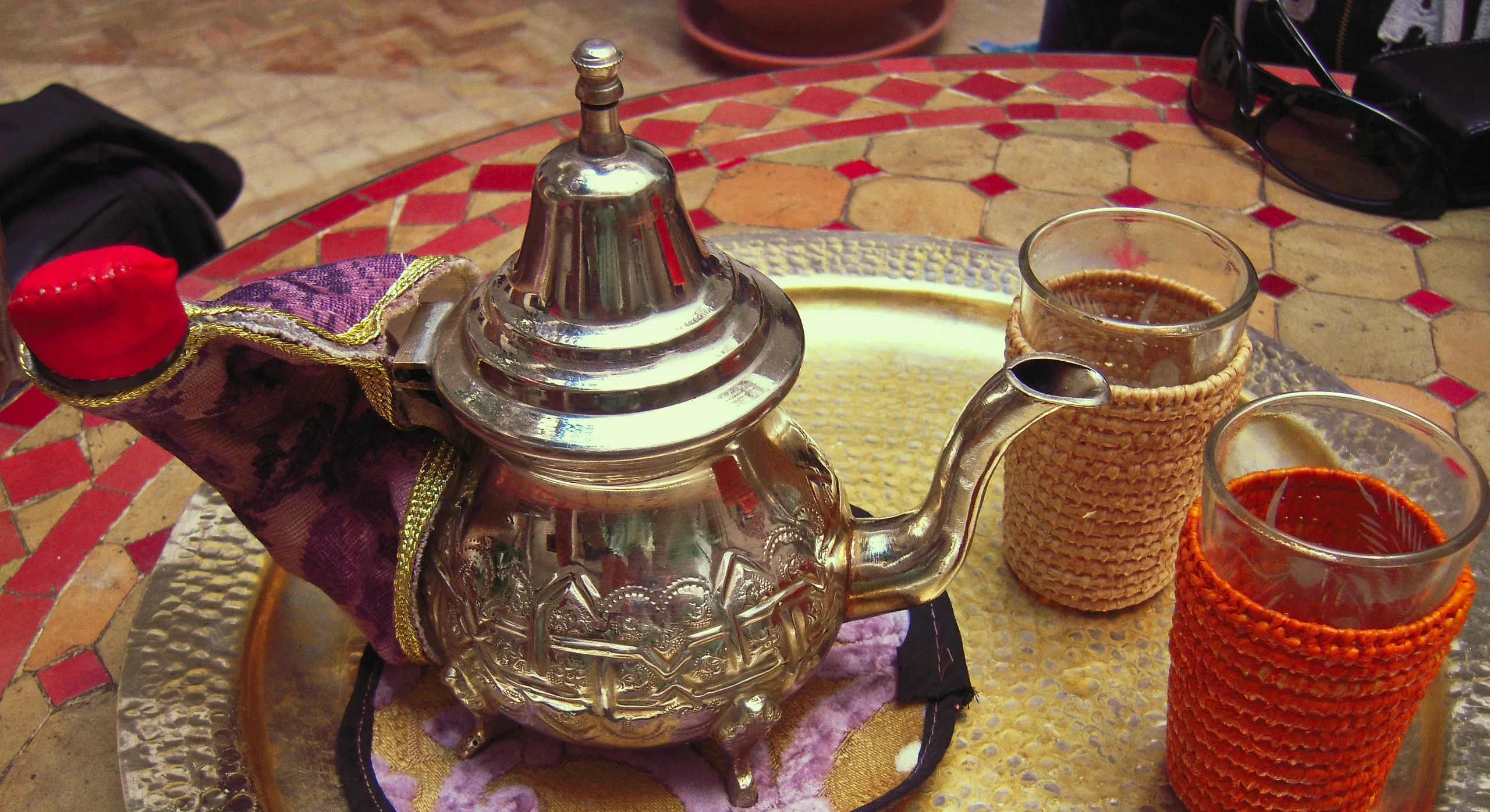 Mint tea poured from a silver teapot into glasses